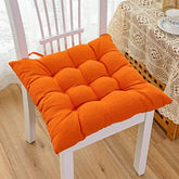 Plush orange tufted cotton seat cushion on a white wooden chair