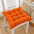 Plush orange tufted cotton seat cushion on a white wooden chair