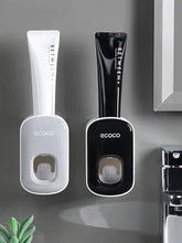 Wall-mounted toothpaste dispensers in white and black, modern bathroom accessory design.
