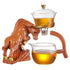 Bull-shaped ceramic tea set with glass teapot and cup containing herbal tea