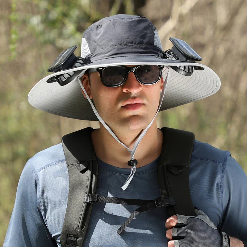 Man wearing wide-brim sun hat with built-in solar fans, outdoor tech streetwear, blue top