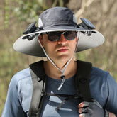 Man wearing wide-brim sun hat with built-in solar fans, outdoor tech streetwear, blue top