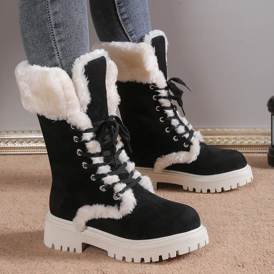 Black suede lace-up winter boots with white faux fur lining and chunky soles, worn with jeans