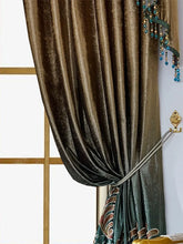 Brown velvet curtain with teal beaded trim, draped and tied back for a luxurious fit