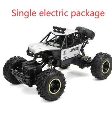 Black and silver electric remote control off-road car with rugged large tires on white background.