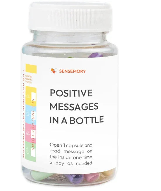 Clear plastic bottle with colorful capsules containing positive messages, white screw cap