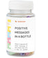 Clear plastic bottle with colorful capsules containing positive messages, white screw cap