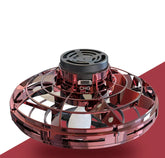 Futuristic red metallic spinning toy drone with protective outer cage on white and red surface