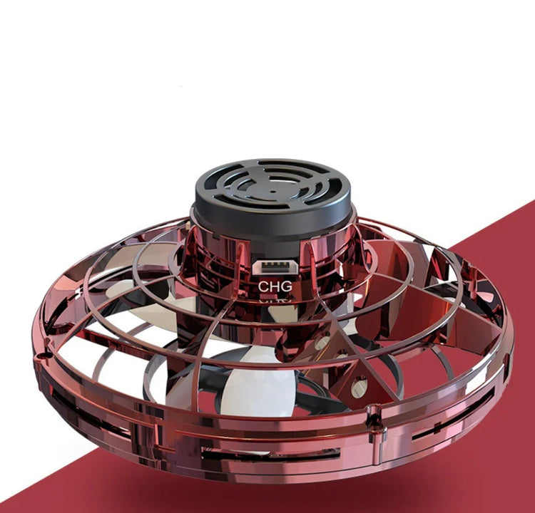 Futuristic red metallic spinning toy drone with protective outer cage on white and red surface