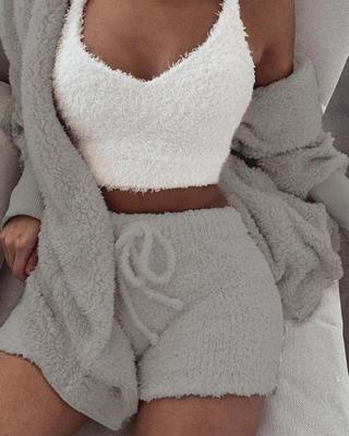 Woman wearing cozy fuzzy lounge set with grey shorts, matching cardigan, and white crop top