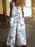 Woman wearing loose-fit white jumpsuit with blue animal print, button front, sleeveless design