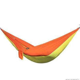 Two-tone orange and green hammock made of lightweight nylon, suspended and empty.