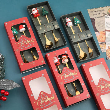 Christmas-themed gold spoon and fork sets with festive character handles in red gift boxes