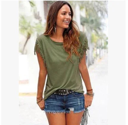 Woman wearing olive green fringe sleeve t-shirt and distressed denim shorts outdoors