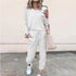Woman in casual white long sleeve jogger set with drawstring waist, relaxed fit, and white sneakers