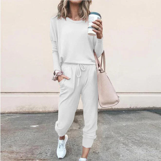 Woman in casual white long sleeve jogger set with drawstring waist, relaxed fit, and white sneakers