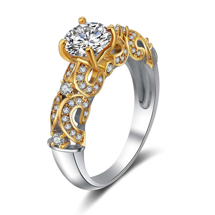Gold and silver ornate engagement ring with clear round gemstones and intricate filigree design.
