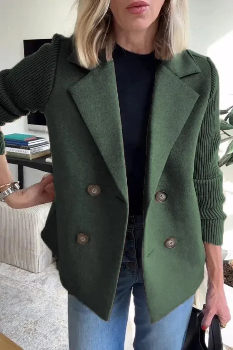 Woman wearing an oversized green wool double-breasted blazer with ribbed sleeves, paired with blue jeans