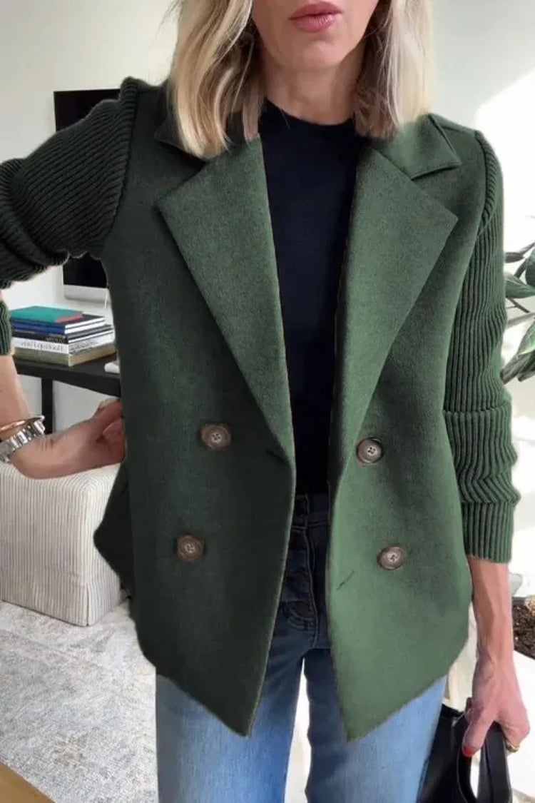 Woman wearing an oversized green wool double-breasted blazer with ribbed sleeves, paired with blue jeans