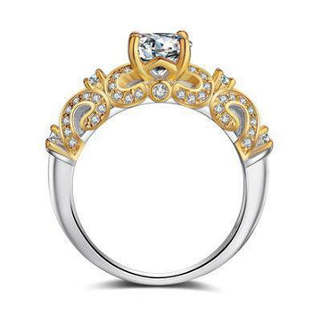 Elegant two-tone ring with gold filigree, clear crystals, and a central gemstone, ornate style
