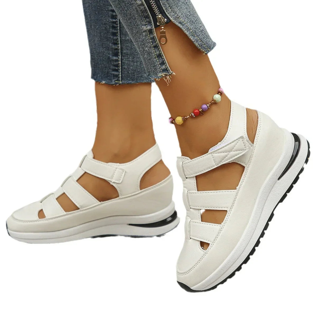 White platform sandals with velcro straps, seen on feet wearing cropped denim jeans