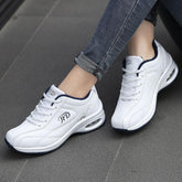 White lace-up sneakers with air-cushioned sole and navy trim, casual fit, worn with skinny jeans