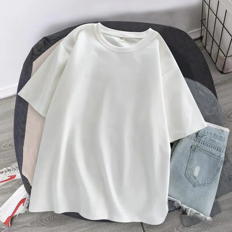 Oversized white short sleeve cotton t-shirt with relaxed fit, paired with light denim shorts