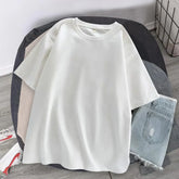 Oversized white short sleeve cotton t-shirt with relaxed fit, paired with light denim shorts