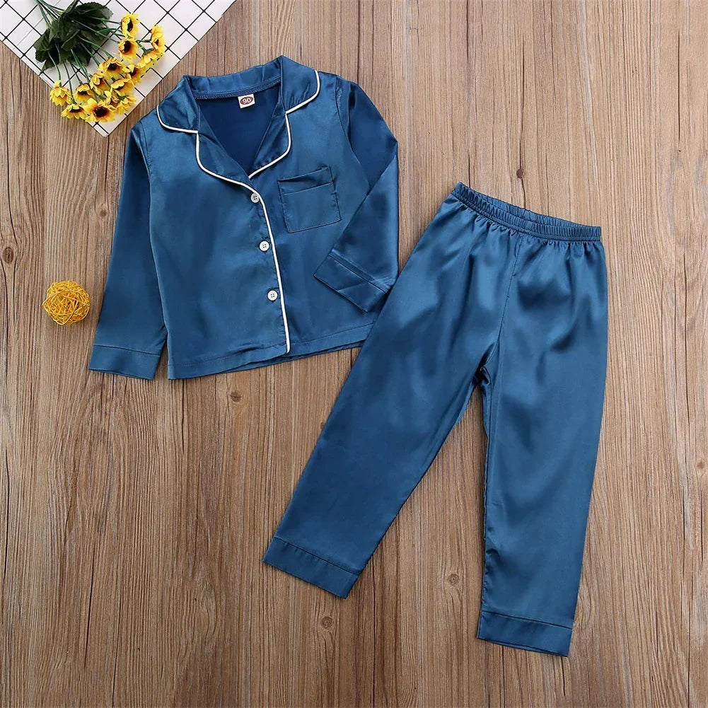 Blue satin long sleeve pajama set with white trim, relaxed fit, on wooden floor