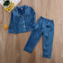 Blue satin long sleeve pajama set with white trim, relaxed fit, on wooden floor