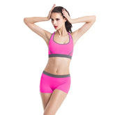 Woman wearing pink athletic sports bra and shorts with gray trim, fitted activewear set