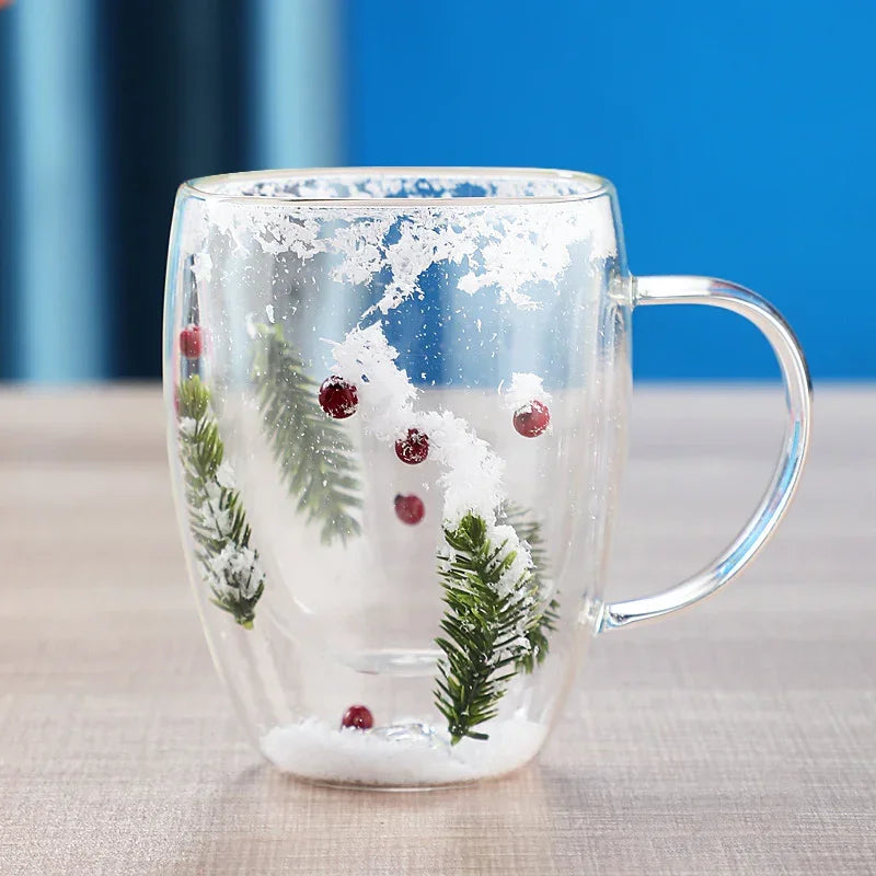 Clear glass mug with winter pine design, red berries, and artificial snow inside.