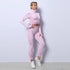 Woman wearing pink seamless textured athleisure set with high-waisted leggings and fitted zip-up crop jacket