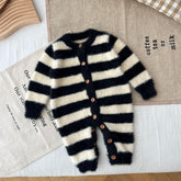 Fuzzy black and white striped baby jumpsuit with wooden buttons, cozy knit material