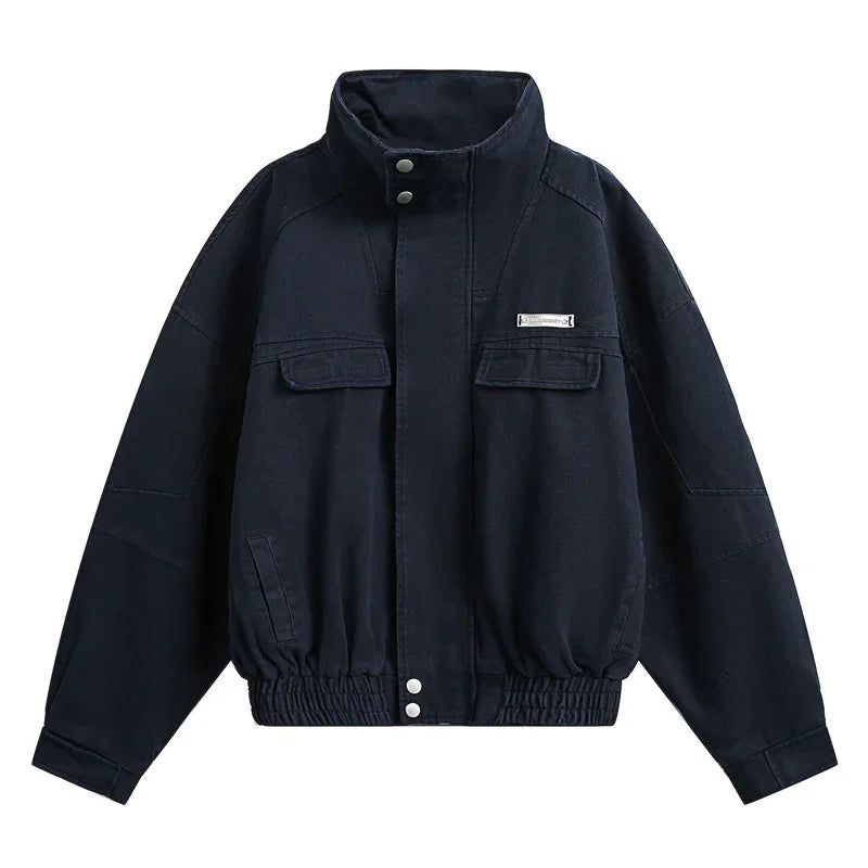 Black oversized bomber jacket with high collar, front pockets, and elastic hem, cotton material