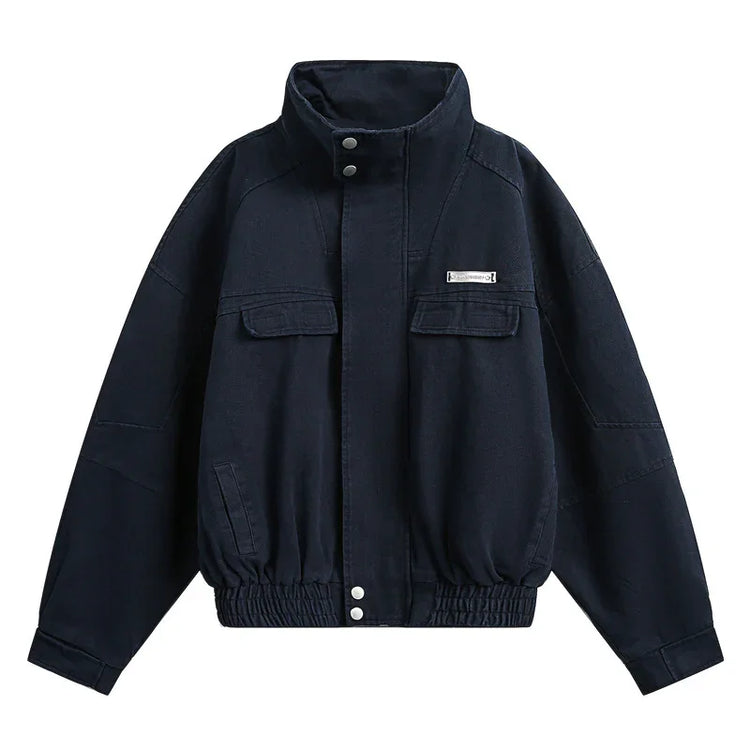 Black oversized bomber jacket with high collar, front pockets, and elastic hem, cotton material
