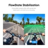 Rider on e-bike with FlowState stabilization ON, showing smooth 360° horizon leveling on sunny palm-lined street