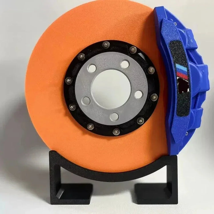 Bright orange and blue futuristic disc-shaped decor with metallic accents, displayed on a stand.