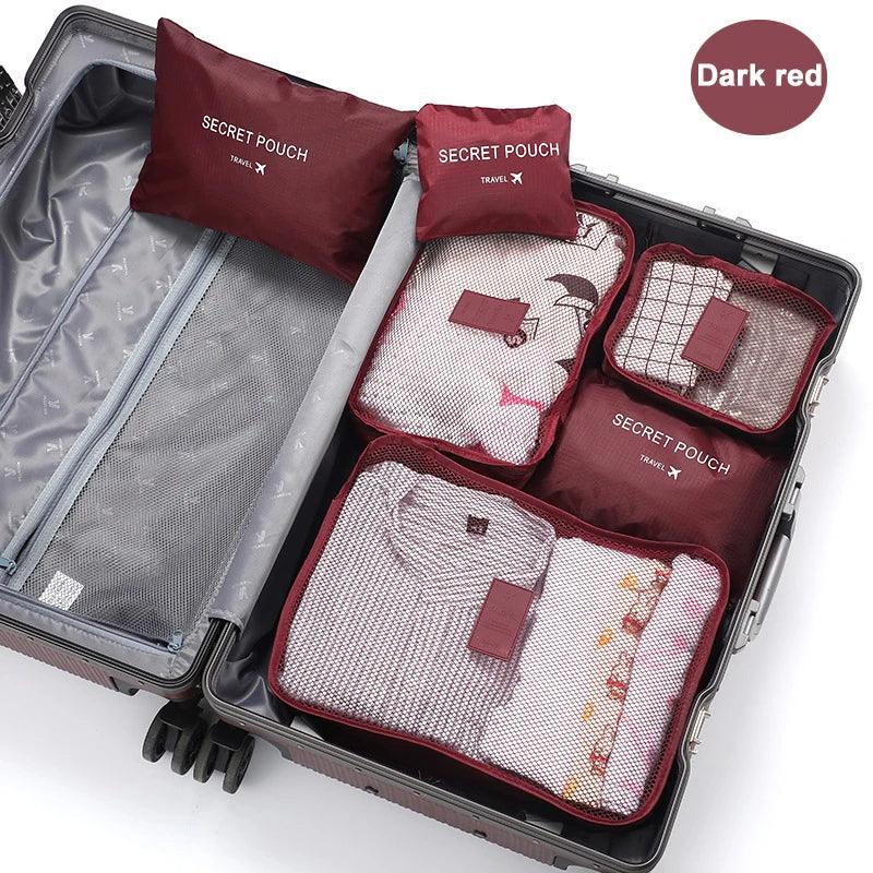 Dark red travel packing cubes with mesh tops neatly organize folded clothing in a suitcase.