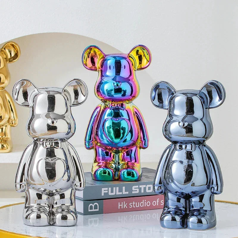 Three metallic bear-shaped figurines in chrome, rainbow, and silver finishes, glossy surface