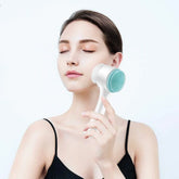 Woman in black spaghetti strap top using a silicone facial cleansing brush