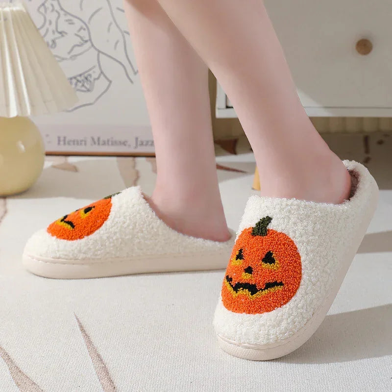 Fuzzy cream slippers with orange jack-o-lantern pumpkin design and cozy closed-toe fit
