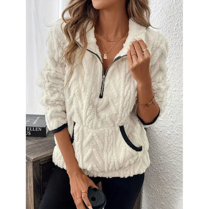 Woman wearing a white fleece pullover with half zip, black trim, relaxed fit and front pocket