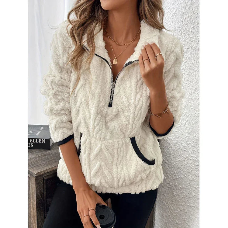 Woman wearing a white fleece pullover with half zip, black trim, relaxed fit and front pocket