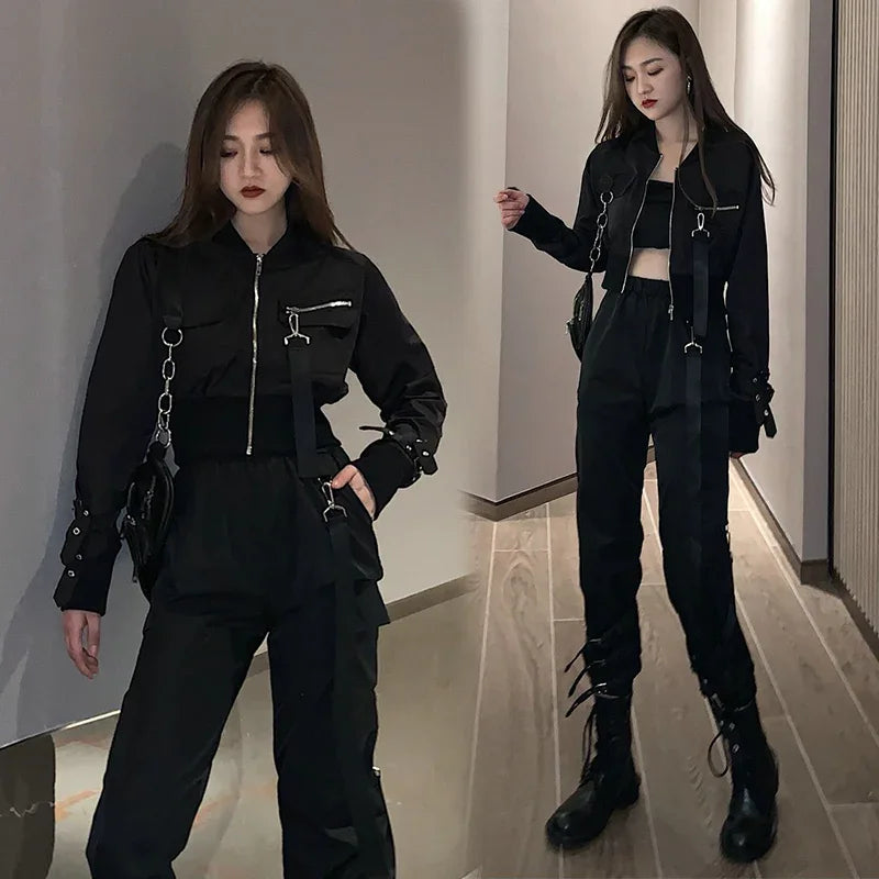 Woman wearing black cropped jacket with zipper, matching high-waisted joggers, and combat boots