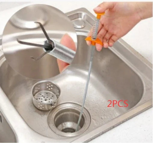 Flexible stainless steel drain cleaning tool with claw tip being used in a kitchen sink
