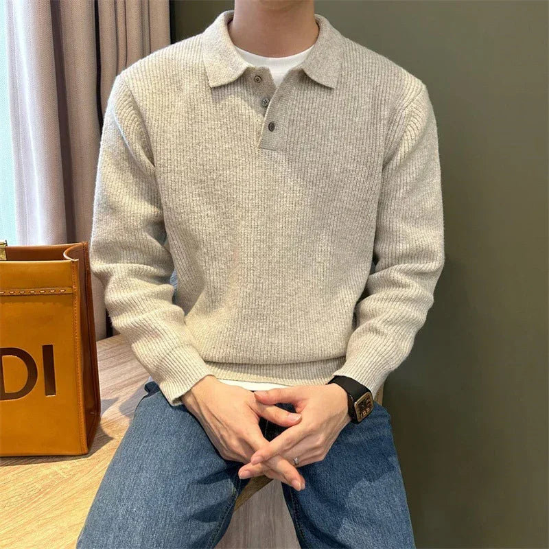 Man wearing a beige ribbed knit pullover sweater with collar and blue jeans, relaxed fit.