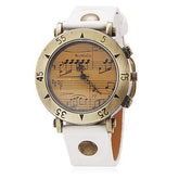Vintage-style wristwatch with a white band, brass case, and musical notes on the dial.