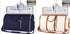 Two duffel travel bags, one navy blue and one cream with tan accents, displayed with hanging dress shirts and toiletry pouches, highlighting spacious, structured design and leather-like trim.