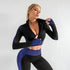 Woman wearing black and blue textured seamless zip-up crop top and matching high-waisted leggings